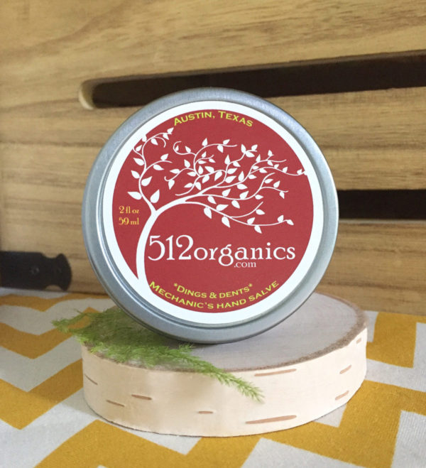 512organics tin of Dings & Dents hand salve with wood background and fern