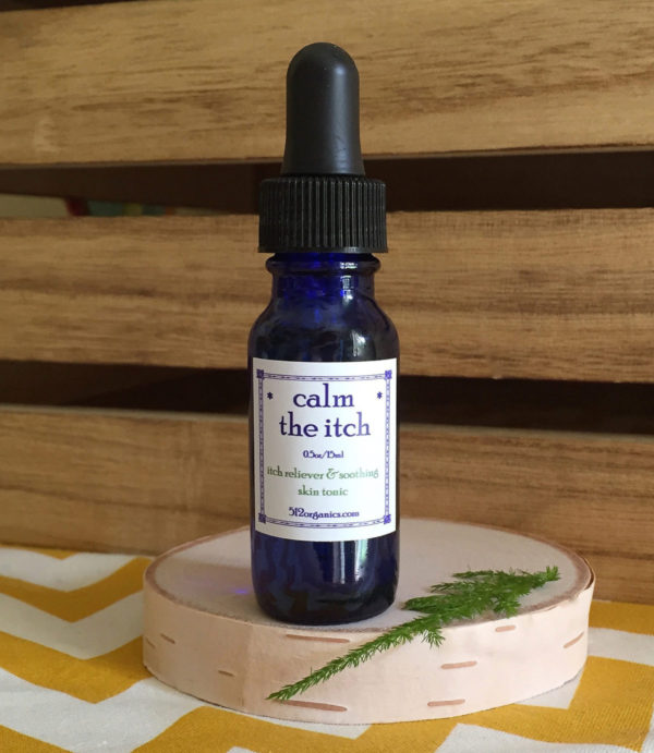 512organics bottle of Calm the Itch essential oils blend 1/2 oz with wood background