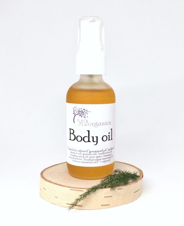 512organics body oil on wood slice with fern